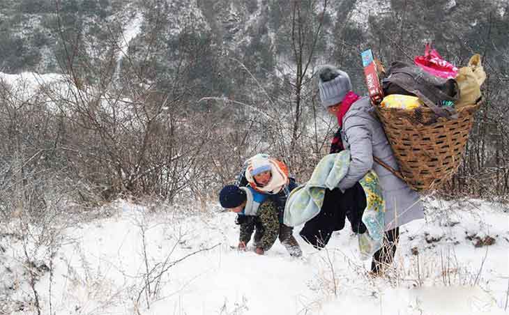 9歲男孩冒雪背弟弟搬新家 200米落差山路走了50分鐘多.jpg